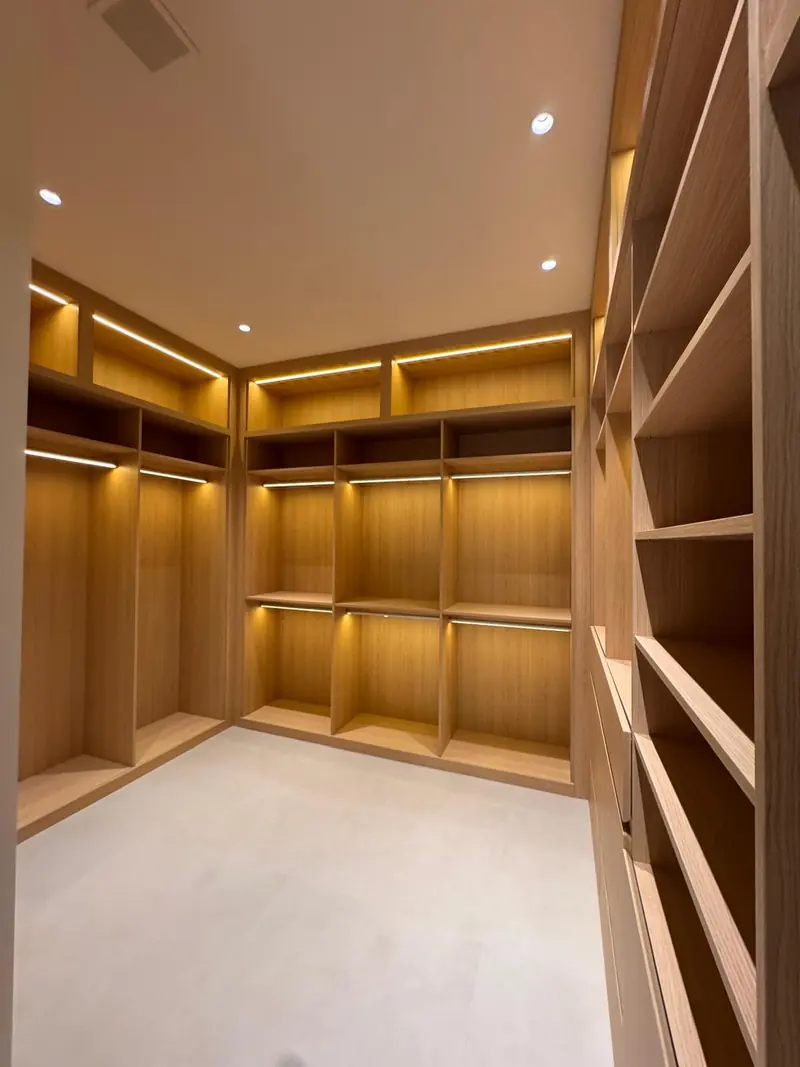 White oak walk-in closet with illuminated shelves by Eco Woodwork & Design